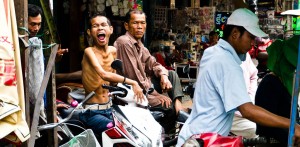 Street Photography in Phnom Penh, Cambodia by Tim Kelsall - moto driver shows his feelings for being photographed