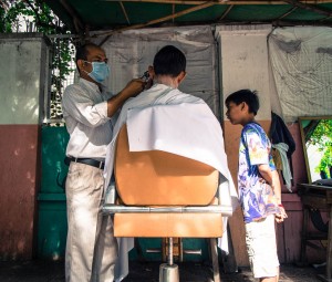 Street Photography in Phnom Penh, Cambodia by Tim Kelsall - open air barber shop at Street 51