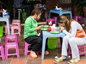 Street Photography in Phnom Penh, Cambodia by Tim Kelsall - two women eating in street 13